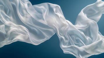 White silk satin cloths are elegantly suspended in mid-air, undulating softly, creating a tranquil atmosphere against a calming blue background, capturing the beauty of fabric in motion photo