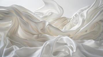 White silk satin cloth delicately floats, creating a wave-like effect in a softly illuminated space. The elegant draping enhances the tranquil atmosphere photo
