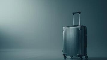 A sleek metallic suitcase is positioned in a softly lit area with a blue hue, evoking thoughts of travel and exploration. The absence of other objects emphasizes its readiness for adventure photo