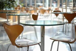 Stylish glass tables and wooden chairs create an inviting atmosphere in a spacious cafeteria photo