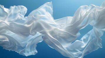 A collection of flowing white silk satin cloths is elegantly suspended in midair, softly billowing in a calm environment. The delicate texture and serene blue backdrop create a peaceful ambiance photo