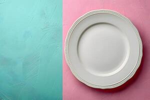 Minimalistic Design for Print Empty White Plate on Colorful Turquoise and Pink Background photo