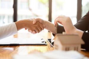 A real estate agent having a meeting with a client in the office to sign a contract, shaking hand. photo