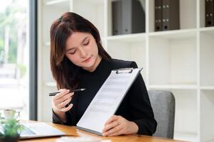 A professional female real estate agent showing and explaining a contract to a client. photo