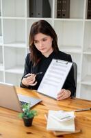 A professional female real estate agent showing and explaining a contract to a client. photo