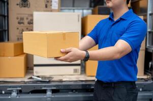 A cropped image of a delivery guy standing at the back of his truck, carrying a package for delivery photo