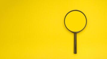 Overhead view of a magnifying glass isolated on a yellow background photo