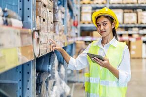 Portrait of asian woman warehouse worker in uniform checks stock and inventory with digital tablet computer, working in delivery, distribution center, logistic and business export photo