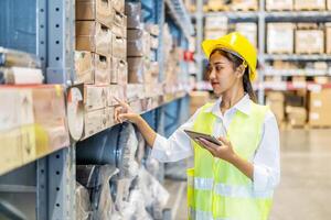Portrait of asian woman warehouse worker in uniform checks stock and inventory with digital tablet computer, working in delivery, distribution center, logistic and business export photo