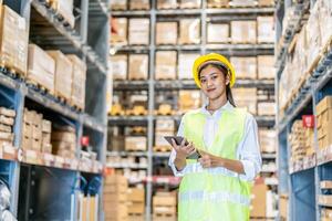 Portrait of asian woman warehouse worker in uniform checks stock and inventory with digital tablet computer, working in delivery, distribution center, logistic and business export photo
