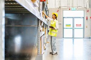 Portrait of asian woman warehouse worker in uniform checks stock and inventory with digital tablet computer, working in delivery, distribution center, logistic and business export photo