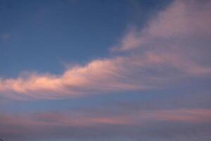 Clouds in the blue sky with white pink clouds on a summer evening on the eve of sunset photo