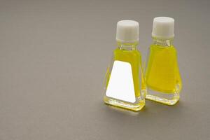 Small bottle containers with yellow herbal. Blank label for branding mockup. Natural beauty and health product concept photo