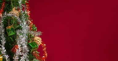 Part of Christmas tree over a red background with copy space for text photo