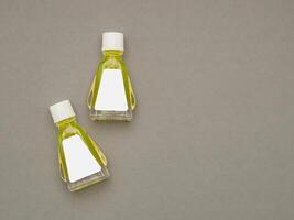 Small bottle containers with yellow herbal. Blank label for branding mockup. Natural beauty and health product concept photo
