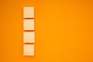Top view of blank four wooden cubes on a yellow background with space for text photo