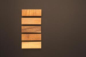 Top view of five empty wooden blocks isolated on a black background. Space for text photo