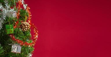 Part of Christmas tree over a red background with copy space for text photo