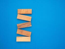 Top view of five empty wooden blocks isolated on a blue background. Space for text photo