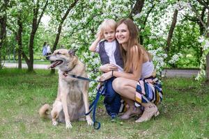 Happy family enjoying quality time with their beloved pet dog in the beautiful park setting. photo