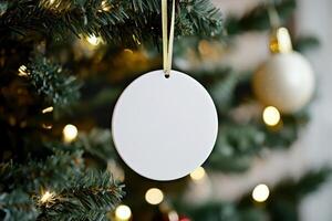 a white round ceramic sublimation decoration on Christmas tree. photo
