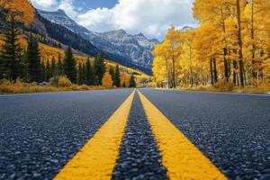 asphalt road with yellow lines. Highway with mountains and autumn trees. Road travel concept. photo