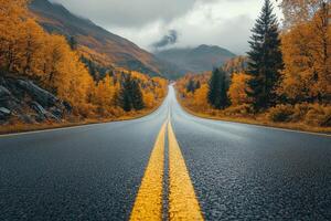 asphalt road with yellow lines. Highway with mountains and autumn trees. Road travel concept. photo