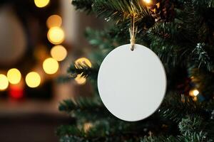 a white round ceramic sublimation decoration on Christmas tree. photo