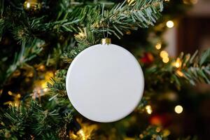 a white round ceramic sublimation decoration on Christmas tree. photo