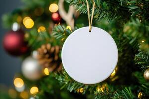 a white round ceramic sublimation decoration on Christmas tree. photo