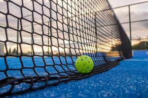 Selective focus. A pickleball ball on the net at sundown photo