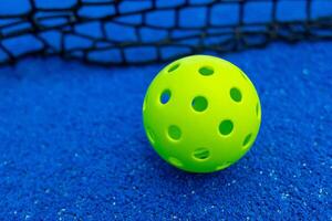 Ball of pickleball in front of the net, racket sports concept photo
