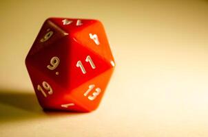 selective focus 20-sided red dice for role-playing game isolated on warm background photo
