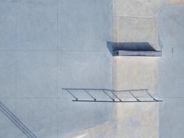 Aerial view of sloped metal rails for grind tricks in an empty concrete skatepark photo