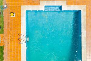 zenithal aerial view with drone of a swimming pool in summer with a pool cleaning robot photo