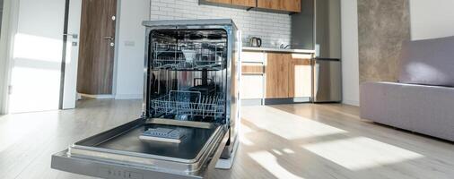 An empty dishwasher, opened, in the modern kitchen of a home. photo