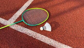 Cream white badminton shuttlecock and racket on badminton court, copy space, soft and selective focus. photo