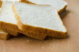 Fresh slices of bread displayed on wooden table. Breakfast concept photo