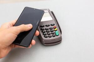Man using NFC technology on smart phone to pay bill photo