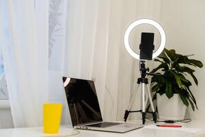 lamp and tripod on the table for online interviews behind a laptop photo