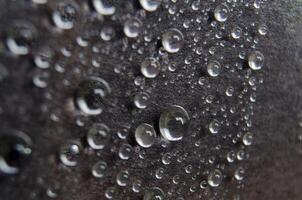 Close up or macro photography of water droplets on dark cover cover background. Water droplets and wallpaper concept photo
