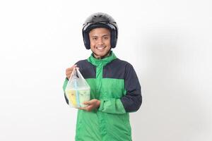 Portrait of Asian online taxi driver wearing green jacket and helmet delivering the beverages in plastic cup to customer. Isolated image on white background photo
