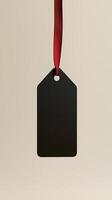Rectangular black blank paper tag label price tag with hanging rope isolated pink photo