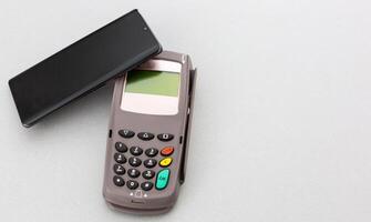 Man using NFC technology on smart phone to pay bill photo