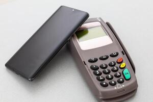 Man using NFC technology on smart phone to pay bill photo