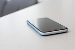 modern mobile phone with blank screen on black stone table background. Smartphone on old dark grey vintage texture background. photo