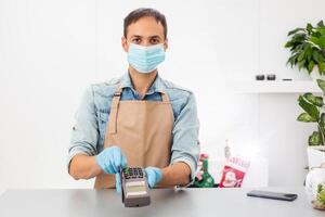Credit card machine for money transaction. hand in gloves with credit card swipe through pos terminal and enter pin code. Banking services of electronic money. Financial success and safety photo