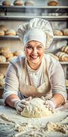 A woman chef is making bread dough in a bakery. She is smiling and wearing a white apron. photo