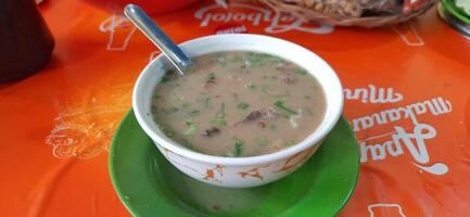 Coto Makassar or Coto Mangkasarak, traditional food from Makassar. Served in a bowl filled with offal and meat and enjoyed with ketupat. Makassar, South Sulawesi, Indonesia - August 31 2024 photo