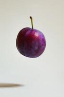 A purple plum is floating in the air photo